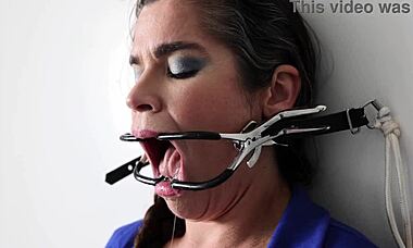 Extreme gag torment as she’s nailed to the wall in brutal bondage play
