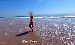 Hustru klär av sig naken på överfylld strand för djärv uppvisning