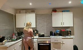 Ella cocina y limpia desnuda en casa. Su cuerpo sexy vapea mientras hace quehaceres.