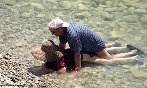 Smyslný podvodní sex s kráskou v klobouku na nudistické pláži