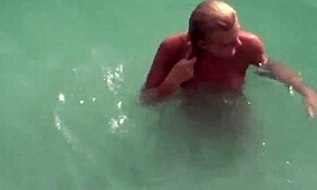 wow, check this topless hottie making out with her nudist boyfriend in the water! 🌊