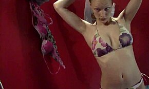 Bezosećajna plavuša zuri prazno dok se presvlači u sobi