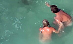 Blond skönhet plaskar naken med sin kille på stranden