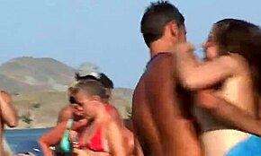 ヌーディストのブロンド爆乳がビーチでトップレスで揺れて、近くに裸の男