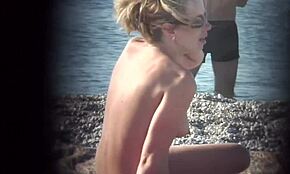 Blondynka pokazuje figurę na plaży nudystów