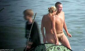 Blondă superbă își etalează corpul gol în apă pe plajă