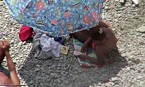 strand voyeur fanger brunette som gir håndjob og blowjob i åpen luft