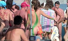 חברות עם צבע גוף חמות מציגות עקומות עירומות בחוף נודיסטי