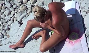 Blonda bejba razkazuje svoje golo telo na plaži na skriti kameri