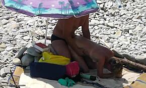 חטובה עם קווי שיזוף מקבלת זיין בסגנון כלב על חוף סלעי