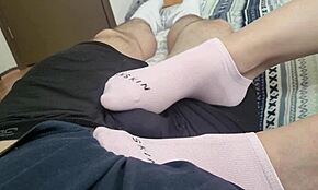 Tínedžerka dráždi vtáka prstami na nohách, dáva nožnú masturbáciu až do vytrysknutia na ponožky