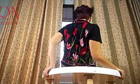 Señora en pantis y tacones hace striptease en mesa redonda