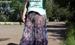 Hårig mogen i genomskinlig klänning blottar utomhus