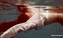 Big-titted redhead Lola poses nude underwater, showcasing her juicy ass