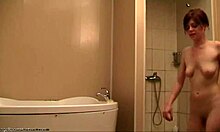 slim brunette shows her naked body while showering on camera