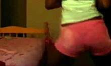 Exotic ebony woman dances and poses in shorts on webcam, showcasing her fabulous designer outfit.