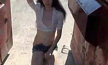 Girl With Stylish Hat Pees Between Trash Cans