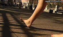 Blonde walks barefoot on streets.