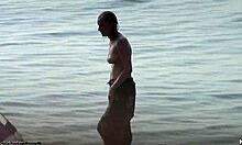 Small-breasted blonde poses on nudist beach.