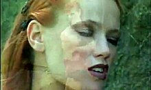 Latex-Clad Redheaded Mistress Poses Seductively by the Wall.