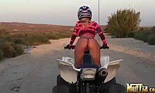 two blonde lesbians ride atvs half-naked, licking in desert