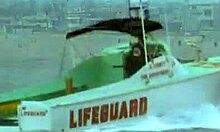 Lifeguard Brunette Assists Girlfriend in Handling a Massive Cock Outdoors in Full Movie