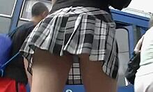Petite amie aux longues jambes en jupe à carreaux chopée en upskirt vidéo outdoor chaude