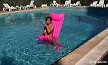 There she was, a busty dark-haired model emerging from the pool. Her perfect naked body glistened under the sun.