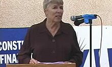 Naked redhead anchorwoman flaunts her tits in front of the camera