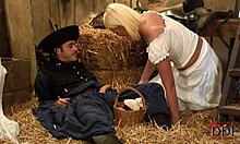 Blond-haired bombshell in white costume with cowboy in barn