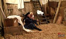 Blond-haired bombshell in white costume with cowboy in barn