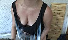 mature blonde wife poses in bedroom, showing big tits with wavy hair