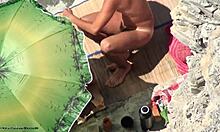 Kinky Nudist Couple Gets Naughty Under Beach Umbrella at Sunset