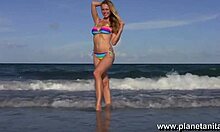 blond beauty flaunts tight body on sunny beach shore