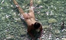 Черт, здоровый парень трахает шлюшку на каменистом пляже после купания