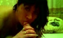 The brunette housewife eagerly sucks a big cock on her homemade bed.