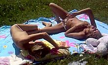 Look at these two slutty girlfriends sunbathing topless on the beach!