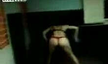 a mature brunette in a thong strips and dances while being filmed at home