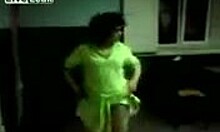 a mature brunette in a thong strips and dances while being filmed at home
