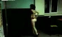 a mature brunette in a thong strips and dances while being filmed at home