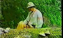 redheaded beauty kneels to suck two cocks. her stockings add to the wild fucking scene.