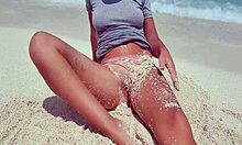 blonde feels pleasure masturbating on sandy beach