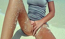 blonde feels pleasure masturbating on sandy beach