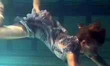 Russian brunette with big tits bounces underwater in the pool, showing her pussy