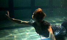 Russian brunette with big tits bounces underwater in the pool, showing her pussy
