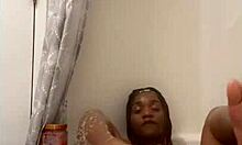 Davina bathes in shower with ebony skin wet and glistening softly