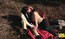 Outdoor picnic turns to lesbian strapon sex for brunette friends.