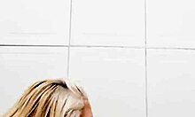 In the bathroom, she inserts a dildo into her pussy