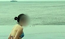 beautiful skinny asian college girl with ponytail relaxing at infinity pool