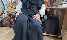 an arab woman sits alone, watching porn on her screen, her hands slowly moving to touch herself as she masturbates deeply.